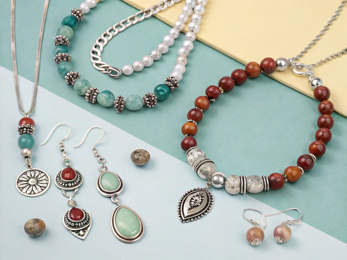 Handcrafted jewelry pieces with natural stones and sterling silver displayed on fabric